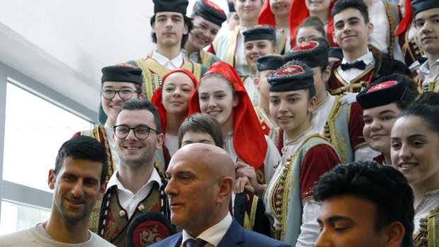 Novak Djokovic, bottom left, poses with top local official Marko Carevic, bottom centre, and children in the municipal building in Budva, Montenegro.