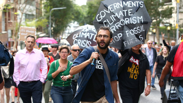 Greens councillor Jonathan Sri leads protesters through the city streets last month. Brisbane alone has seen several climate action protests this year. 