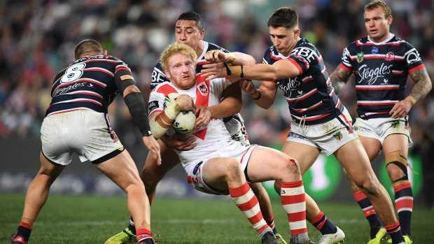 Outnumbered: James Graham is collared by the willing Roosters defence.