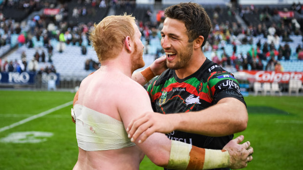 Best of enemies: Dragons' James Graham and Rabbitohs' Sam Burgess embrace after full-time.