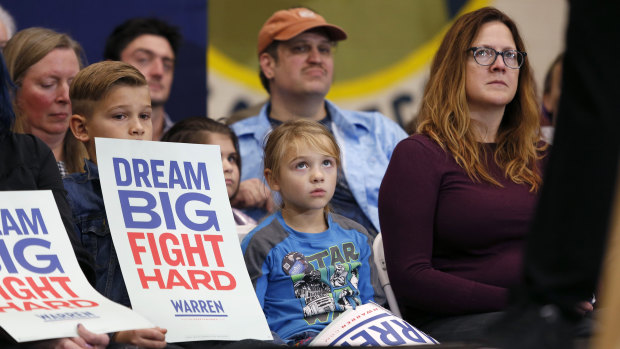 A child looks up as Democratic presidential candidate Senator Elizabeth Warren speaks during a campaign stop.
