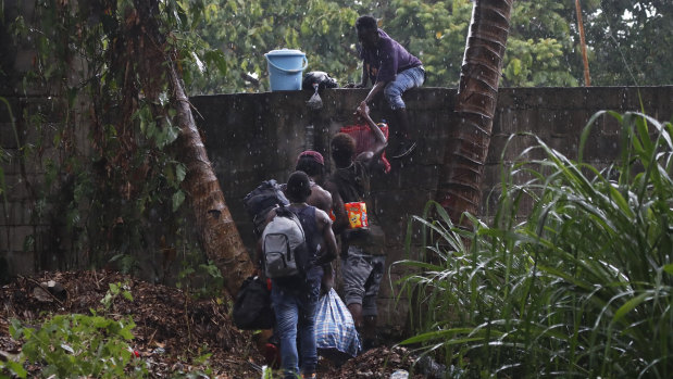 Haitian migrants jump the wall of the Mesoamericana fairgrounds to look for food, in Tapachula, Chiapas state, Mexico. 