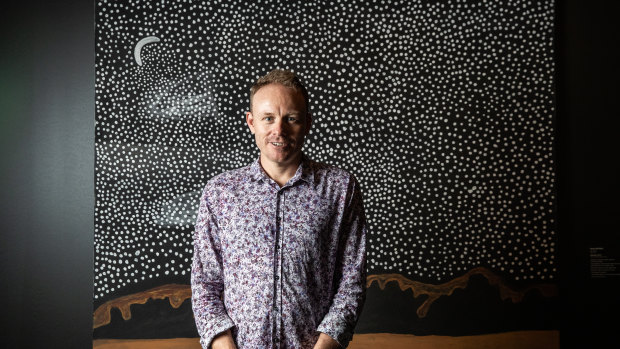 Luke Scholes, curator of Aboriginal art and material culture at the Museum and Art Gallery of Northern Territory, in front of Peters' artwork Garnkiny.