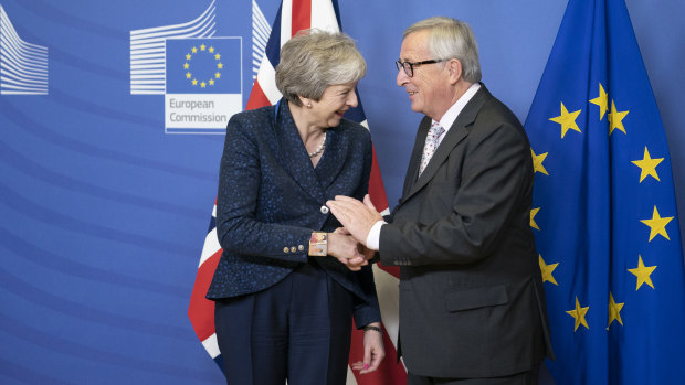 Theresa May, left, shakes hands with Jean-Claude Juncker, president of the European Commission, during a meeting in Brussels on Saturday.