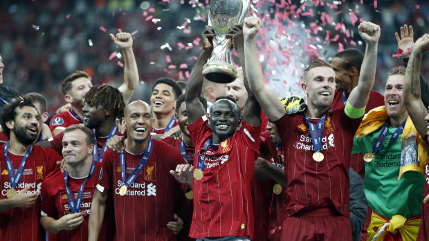Liverpool's Sadio Mane raises the trophy to celebrate with teammates after winning the UEFA Super Cup.
