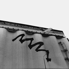 The silos, pictured in 1993, were painted with a mural to support Sydney’s bid for the 2000 Olympic Games. Now-defunct airline Ansett was one of the first advertisers on the billboard.