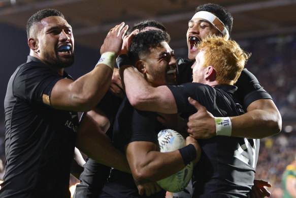 New Zealand’s Richie Mo’unga is congratulated by teammates after scoring a try. 