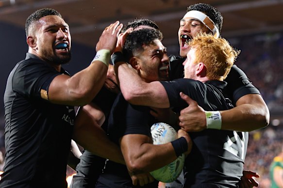 New Zealand’s Richie Mo’unga is congratulated by teammates after scoring a try. 