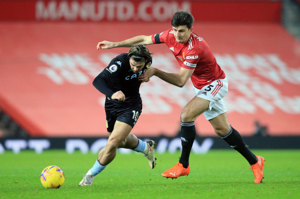 Aston Villa's Jack Grealish (left) battles for possession with United's Harry Maguire.