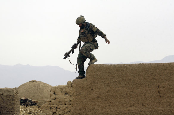 A US special operations forces soldier climbs down from a compound wall in Shewan, a former Taliban stronghold in Afghanistan's Farah province.