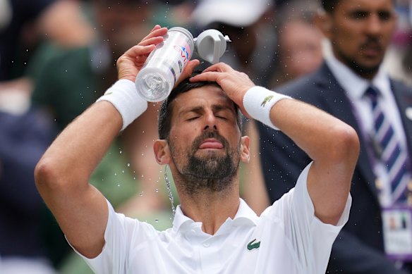 Novak Djokovic douses himself in water to cool down.