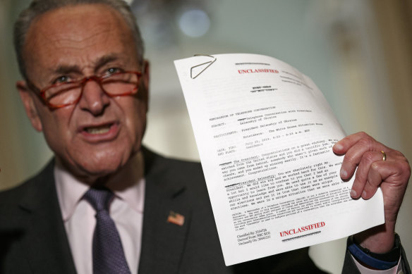 Senate Minority Leader senator Chuck Schumer holds up a copy of a released transcript of a phone call between President Donald Trump and the President of Ukraine.