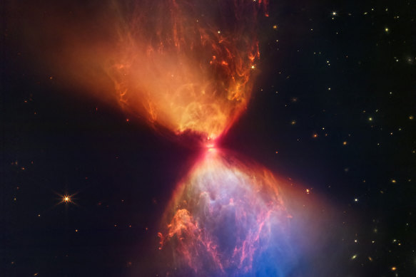 Deep in a cloud of dust and gas, a star is being born. At the center of the hourglass light from a spinning shrinking protostar leaks out the top and bottom of a thick disc of matter feeding it and illuminates surrounding gas and dust clouds.