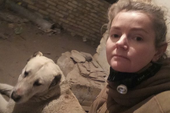 Anna-Mariia Mykytiuk cares for a dog in the basement of her veterinarian hospital during an artillery attack in the Russian occupation of Bucha.