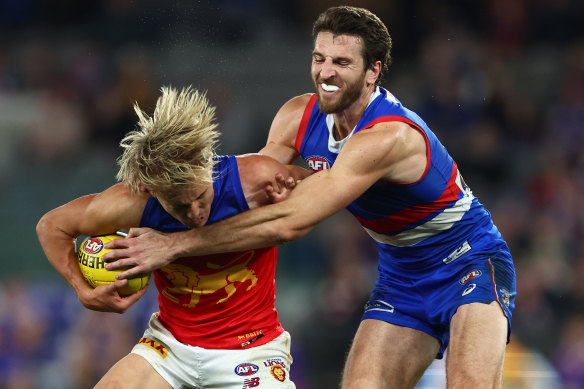 The Lions’ Kai Lohmann is tackled by Bulldogs champion Marcus Bontempelli.