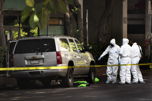 Forensic investigators examine a vehicle following the assassination attempt in Mexico City.