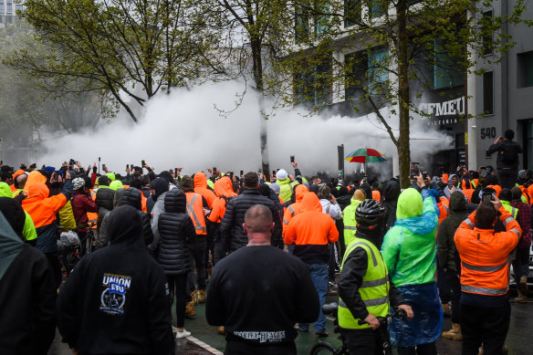 People inside the CFMEU office fend off protesters with fire extinguishers on Monday.