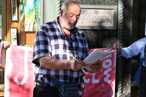Activist Stephen Langford reads poetry outside the Downing Centre court.