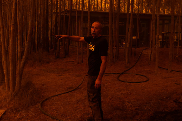 Grant managed to save his property near the Princes Highway. He points towards the dam where he submerged himself for an hour to survive as the fire raged.