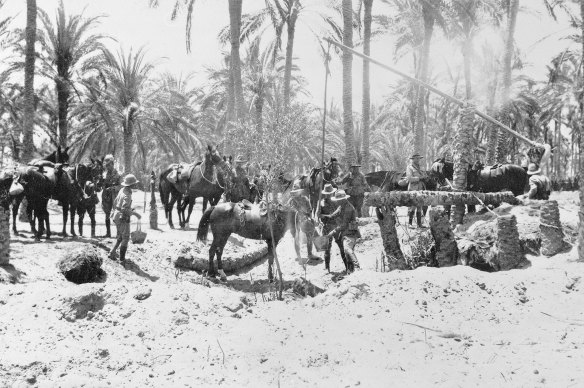 Australian Light Horsemen watering their horses at a well in the desert.