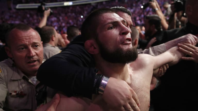 Khabib Nurmagomedov being held back outside the cage.