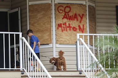 Noah Weibel and his dog, Cookie, outside their home as the family prepares for Hurricane Milton.
