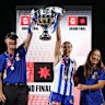 Darren Crocker, Senior Coach of the Kangaroos, Jasmine Garner of the Kangaroos and Nicole Bresnehan of the Kangaroos hold the Premiership Cup aloft.