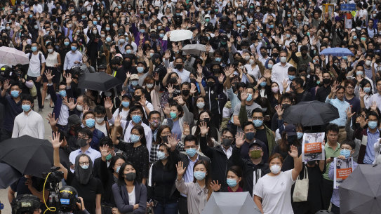 Protesters hold up their hands to represent their five demands as protests continue in Central, Hong Kong, at lunchtime on Tuesday.