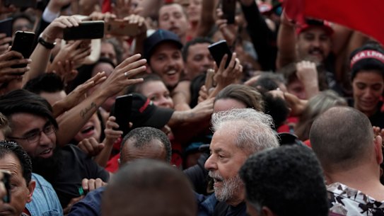 Brazil's former president Luis Inacio Lula da Silva, bottom, is mobbed by supporters as he is freed on Friday.