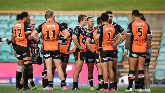 Wests Tigers players in a huddle after conceding one of many tries on Sunday afternoon against the Rabbitohs.