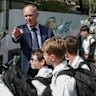 Brett Collison, the director of junior school at Xavier College, with students who travel home on school buses.