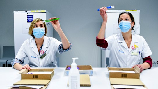 Health workers in Belgium inspect vials of the Pfizer-BioNTech coronavirus COVID-19 vaccine, which is one of the candidates expected to receive approval in Australia by the end of January.