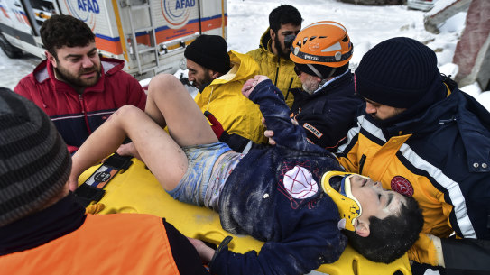 Rescue workers and medics carry a survivor, eight-year-old boy Arda Gul, from the debris of a collapsed building in Elbistan, Kahramanmaras, in southern Turkey.