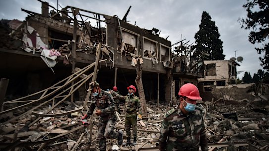 Azerbaijani soldiers search for survivors after rocket fire by Armenian forces.