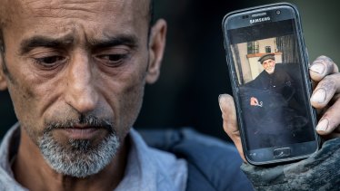 Omar Nabi holds a photo of his father Haji Daoud, who was killed in the attack.