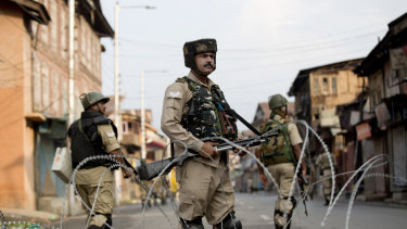 Indian paramilitary soldiers stand guard during curfew in Srinagar on August 7.