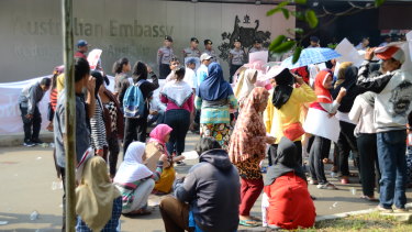 Protesters, some of whom were paid to attend, sit around bored at a rally outside the Australian embassy in Jakarta.