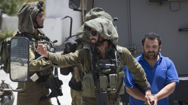 Israeli soldiers make one of several arrests of Palestinians last month after a soldier was killed by a rock thrown from a rooftop in the West Bank village of Yabad.