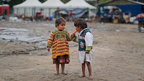 Two homeless children share an ice block in New Delhi. Some 800 million people in India live in poverty, many of them migrating to big cities in search of a livelihood and often ending up on the streets. 