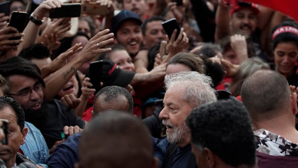 Brazil's former president Luis Inacio Lula da Silva, bottom, is mobbed by supporters as he is freed on Friday.