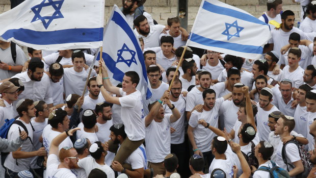 Israeli youths wave national flags outside the Old City's Damascus Gate.