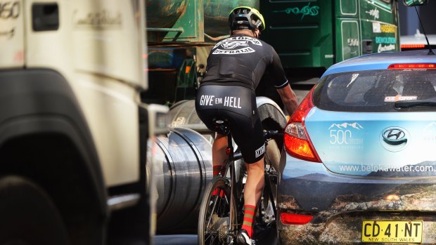 A cyclist in traffic in the Sydney CBD.