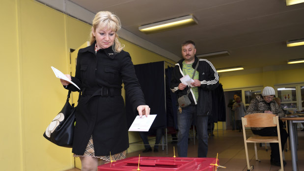 A Latvian woman casts her ballot papers at a polling station in Riga, Latvia, on Saturday.