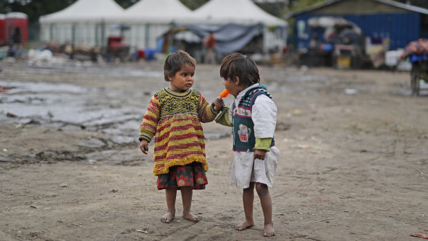 Two homeless children share an ice block in New Delhi. Some 800 million people in India live in poverty, many of them migrating to big cities in search of a livelihood and often ending up on the streets. 
