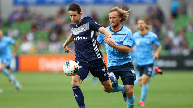 Full steam ahead: Victory striker Robbie Kruse surges forward as Sydney's Rhys Grant gives chase.