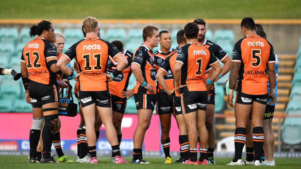 Wests Tigers players in a huddle after conceding one of many tries on Sunday afternoon against the Rabbitohs.