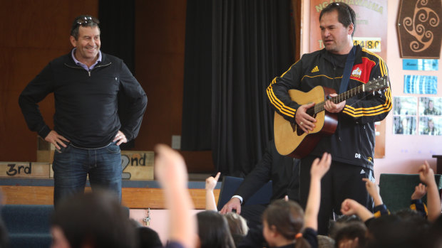 Loves a sing-song: Wayne Smith and then-Chiefs coach Dave Rennie talk to school students in 2012.