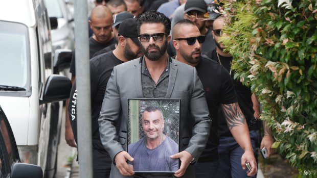 Mourners carry a photo of Mick Hawi during his funeral in February.