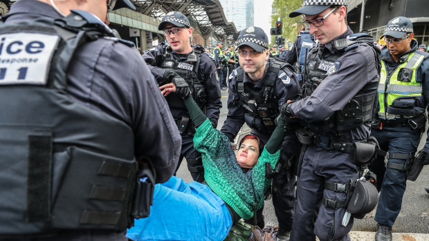 An Extinction Rebellion protester is stopped by police on Thursday.