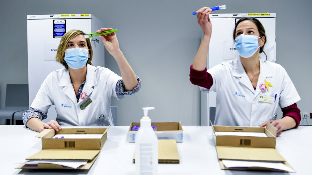 Health workers in Belgium inspect vials of the Pfizer-BioNTech coronavirus COVID-19 vaccine, which is one of the candidates expected to receive approval in Australia by the end of January.
